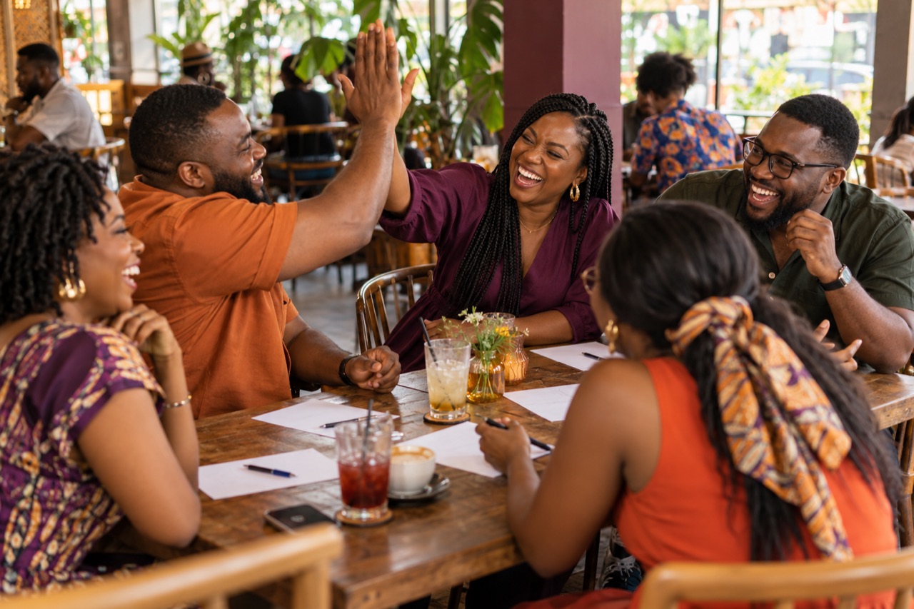 Illustrative scene of Nigerian adults celebrating a trivia answer together
